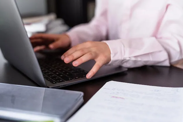 Arbeitnehmer überprüft Gehaltsband-Dokumente auf dem Laptop: Grundgehalt sowie Bandbreite