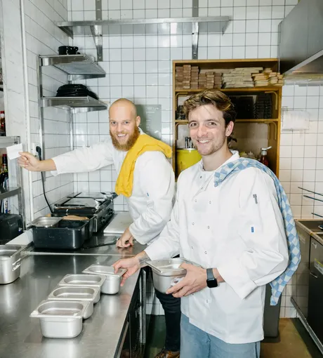 Two chefs prepping service in a restaurant kitchen