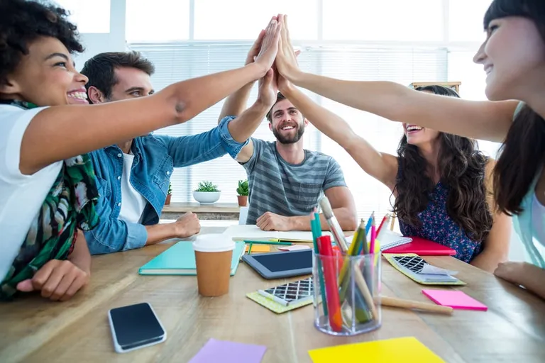 Équipe réunissant leurs mains au bureau