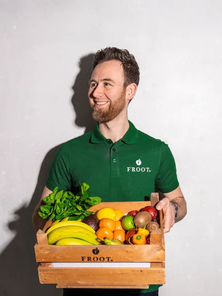 Froot employee holding a crate of fresh fruit