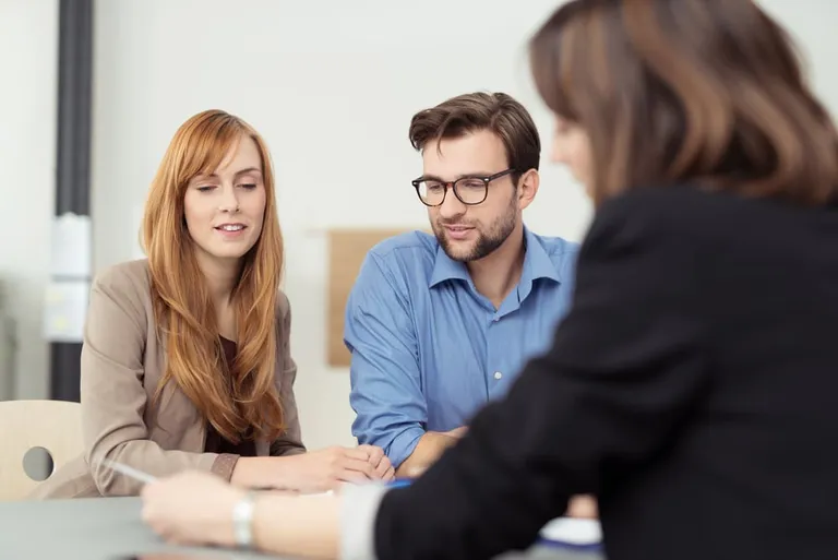 Conseiller présentant un document à un couple