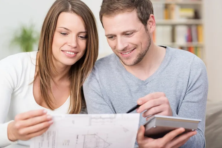 Couple discutant d’un achat avec documents et calculatrice