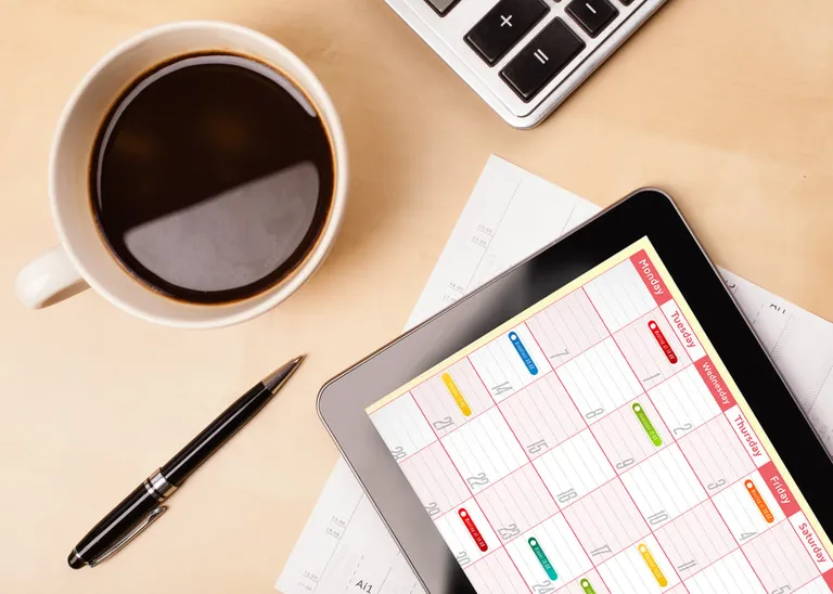 Tablet showing calendar on wooden desk