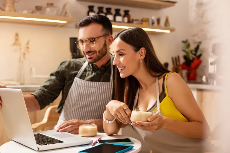 Managers reviewing a schedule on a laptop in a restaurant or café
