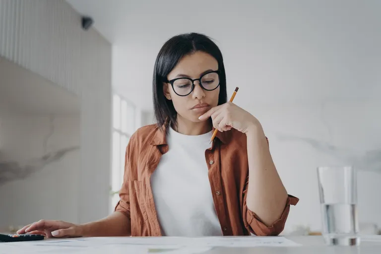 femme avec lunettes calculant des dépenses