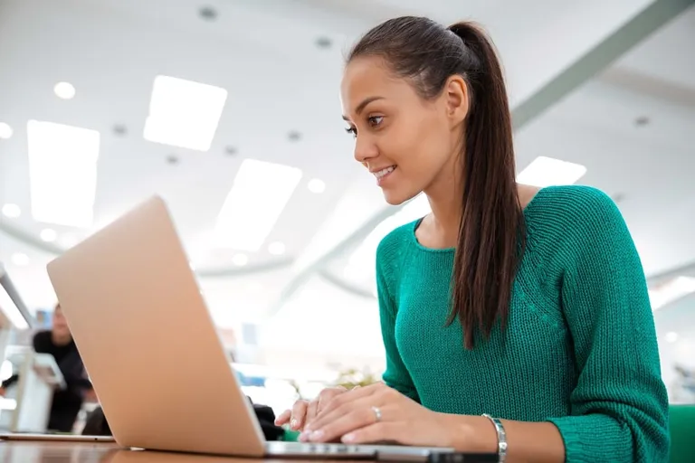 Étudiante souriante utilisant un ordinateur portable à l'université