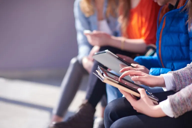Students collaborating on a project with a tablet