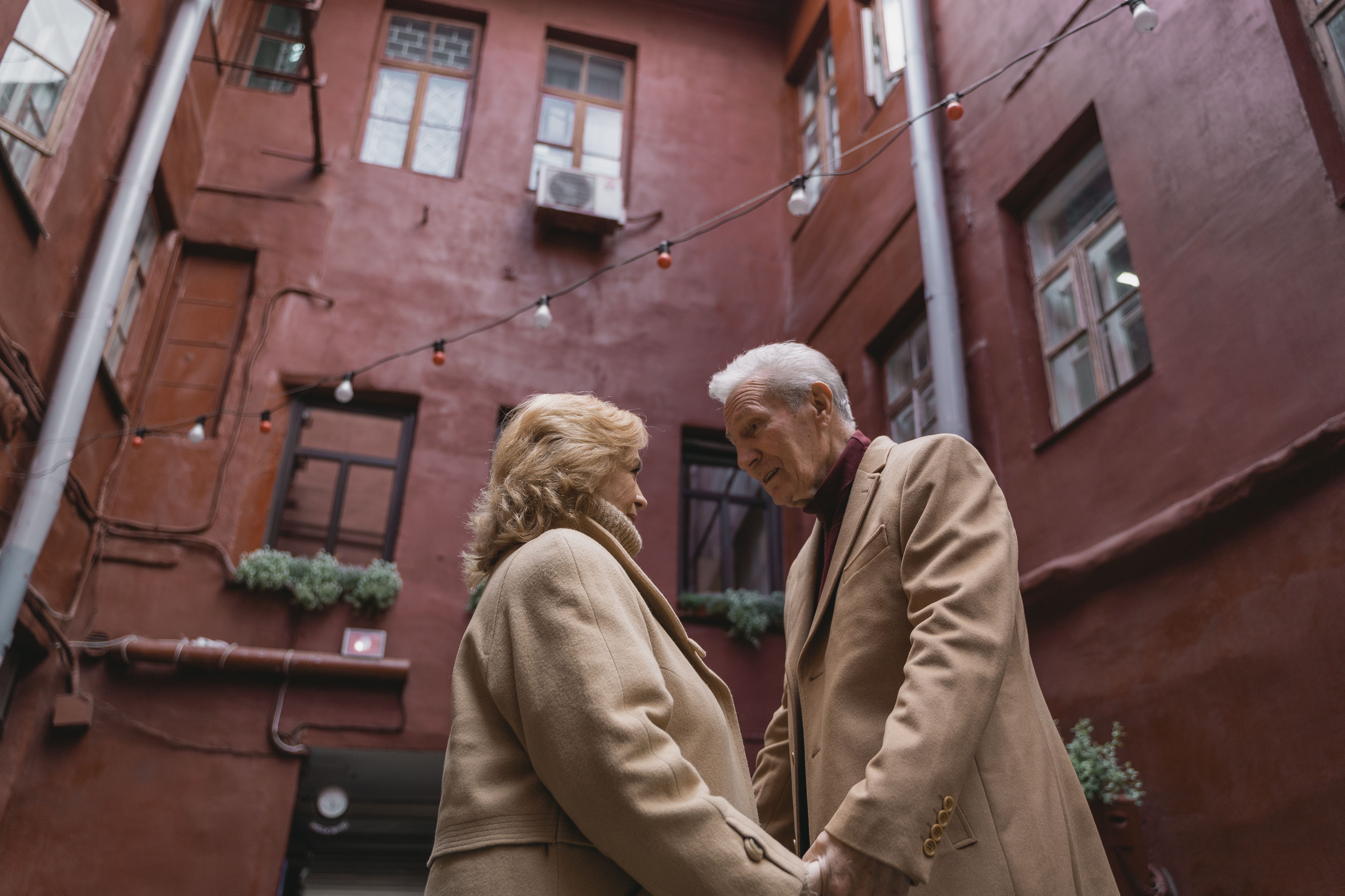 An older couple holds hands and looks at each