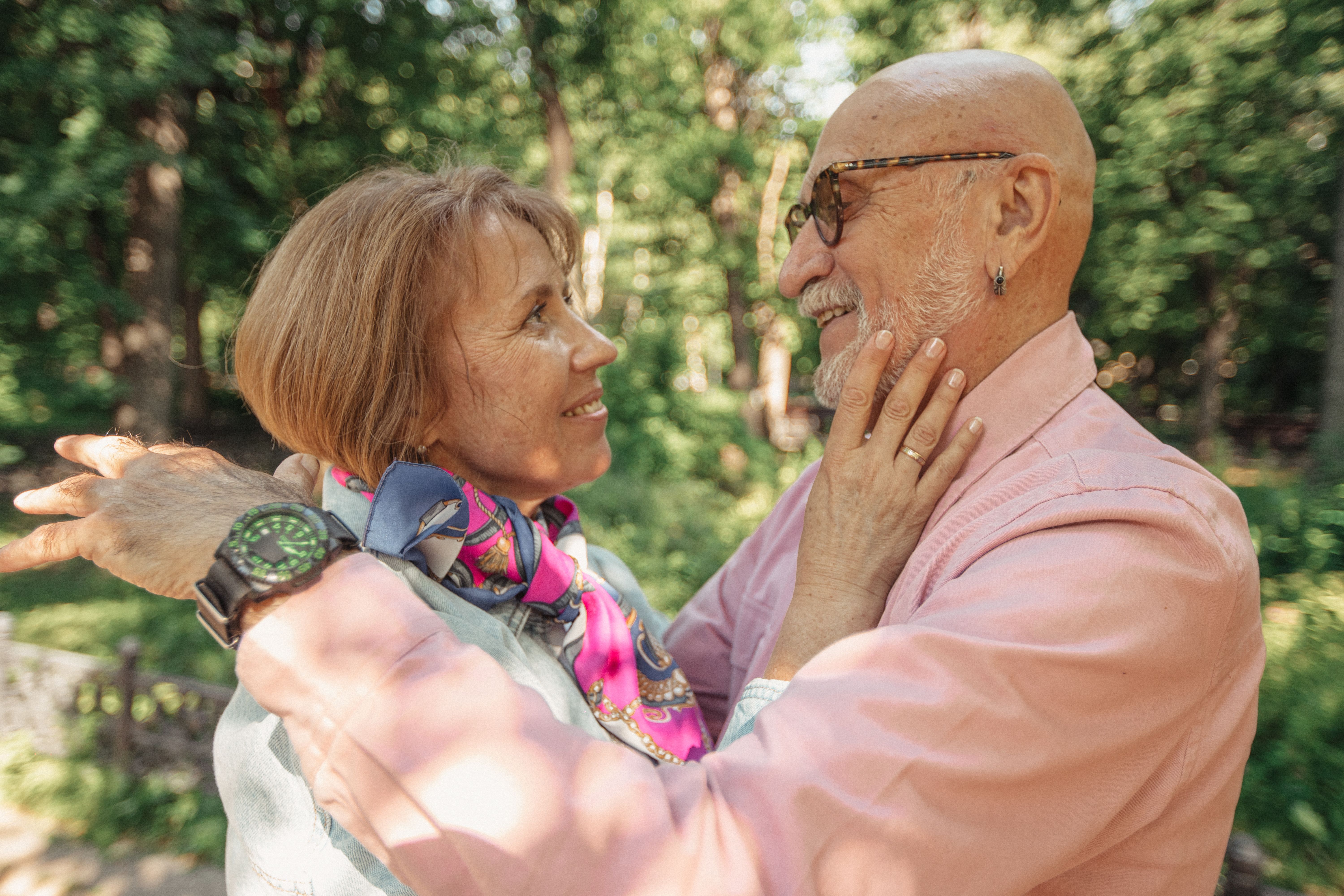 Close-up of a senior couple embracing in a lush green park