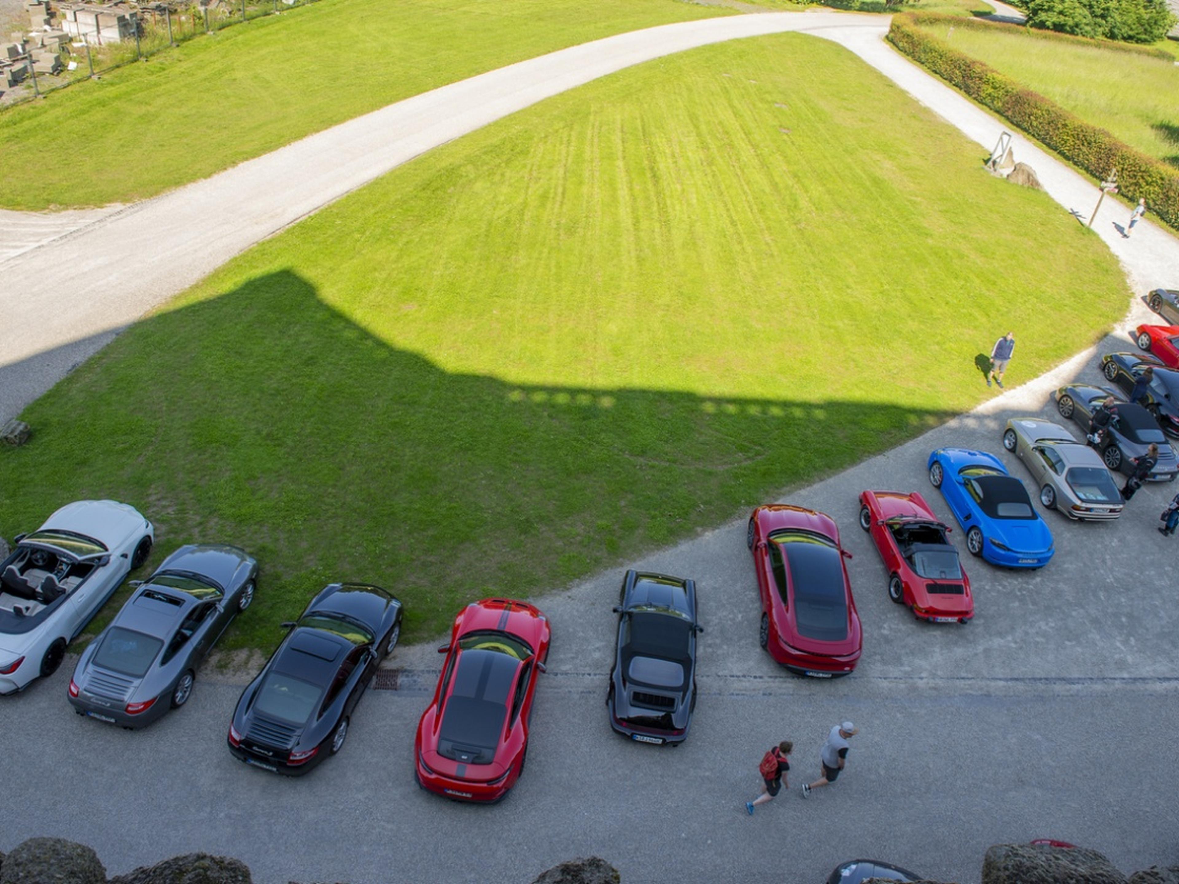 Mehrere Porsche fahren eine Serpentinenstraße entlang.