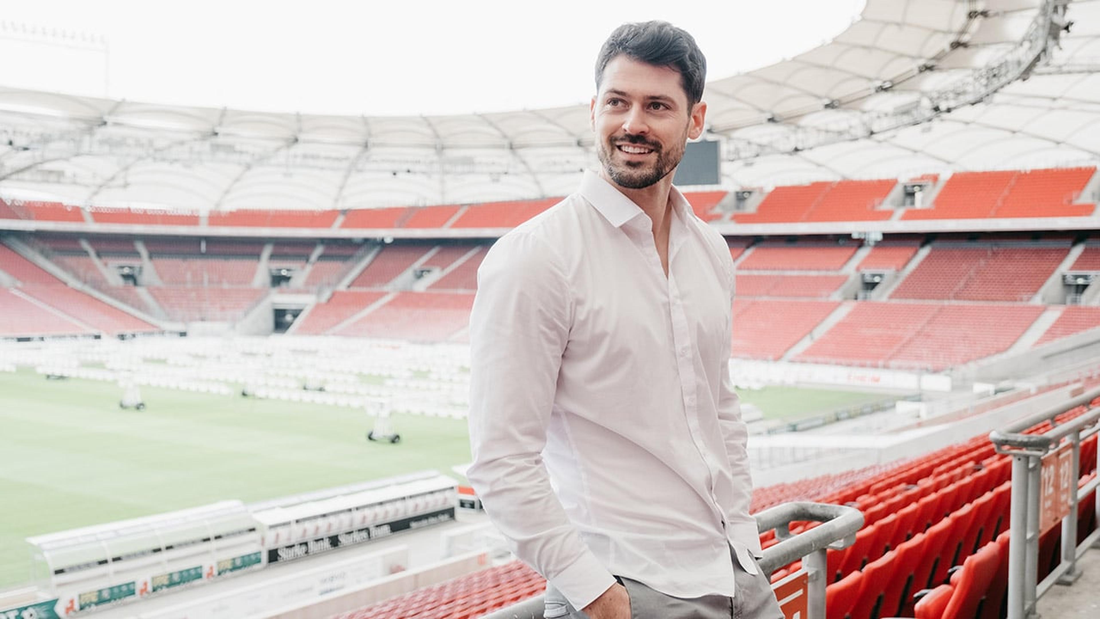 Florian Rudy steht in einem leeren Fußballstadion auf der Zuschauertribüne.