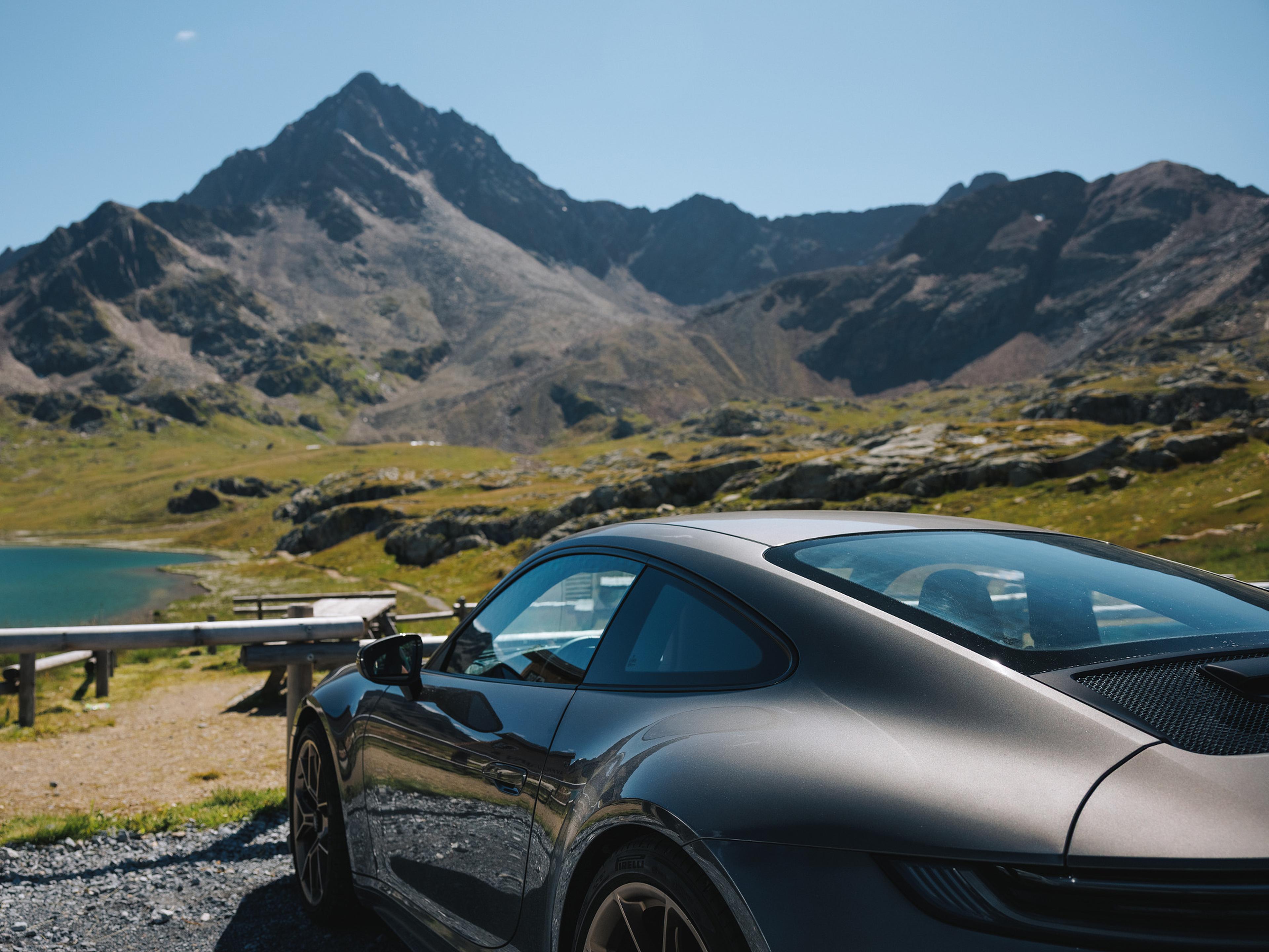Ein Porsche Sportwagen steht vor einer Berglandschaft.