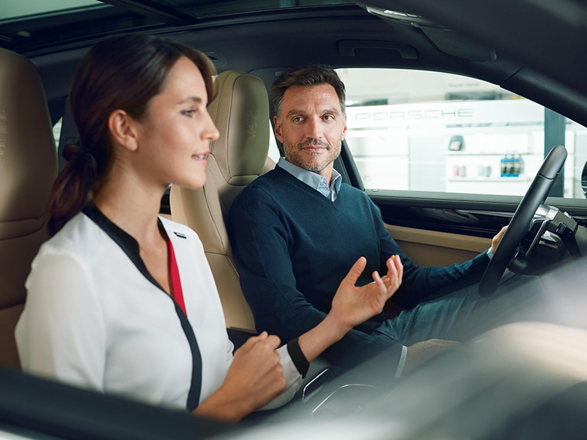 Ein Mann und eine Frau sitzen in einem Fahrzeug.