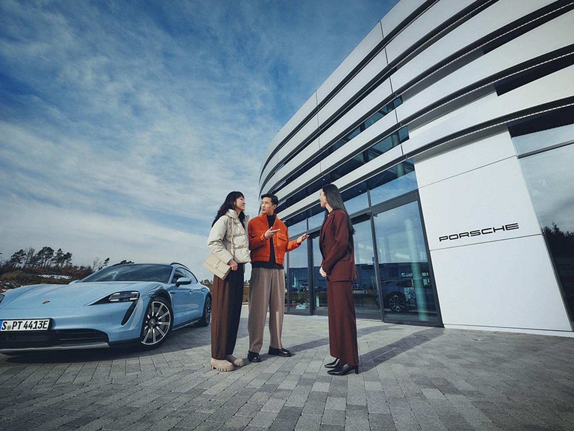 Porsche Kunden werden draußen vor dem Porsche Zentrum empfangen.