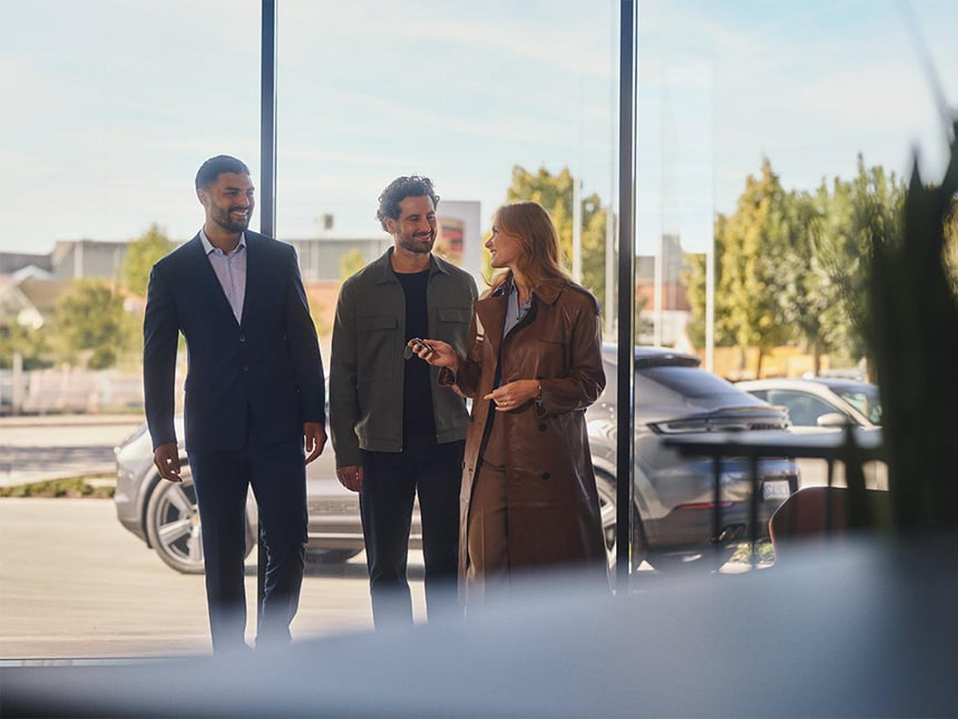 Fahrzeugabholung und Schlüsselübergabe mit einem Porsche Kunden und einem Porsche Servicemitarbeiter.