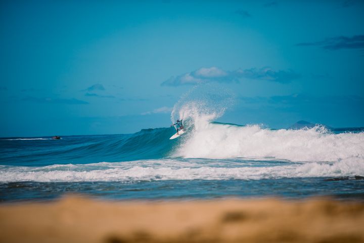 Surfer auf der Welle vor Kauai