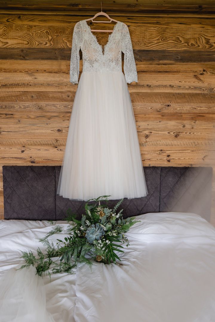 Kleid und Brautstrauß am Bett