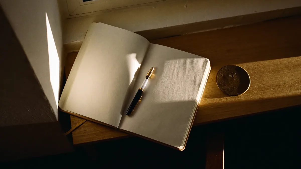 Open notebook and pen on a desk in morning light