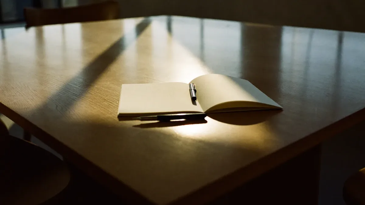 Notebook, pen and coffee on a meeting table during a Dubai marketing planning session