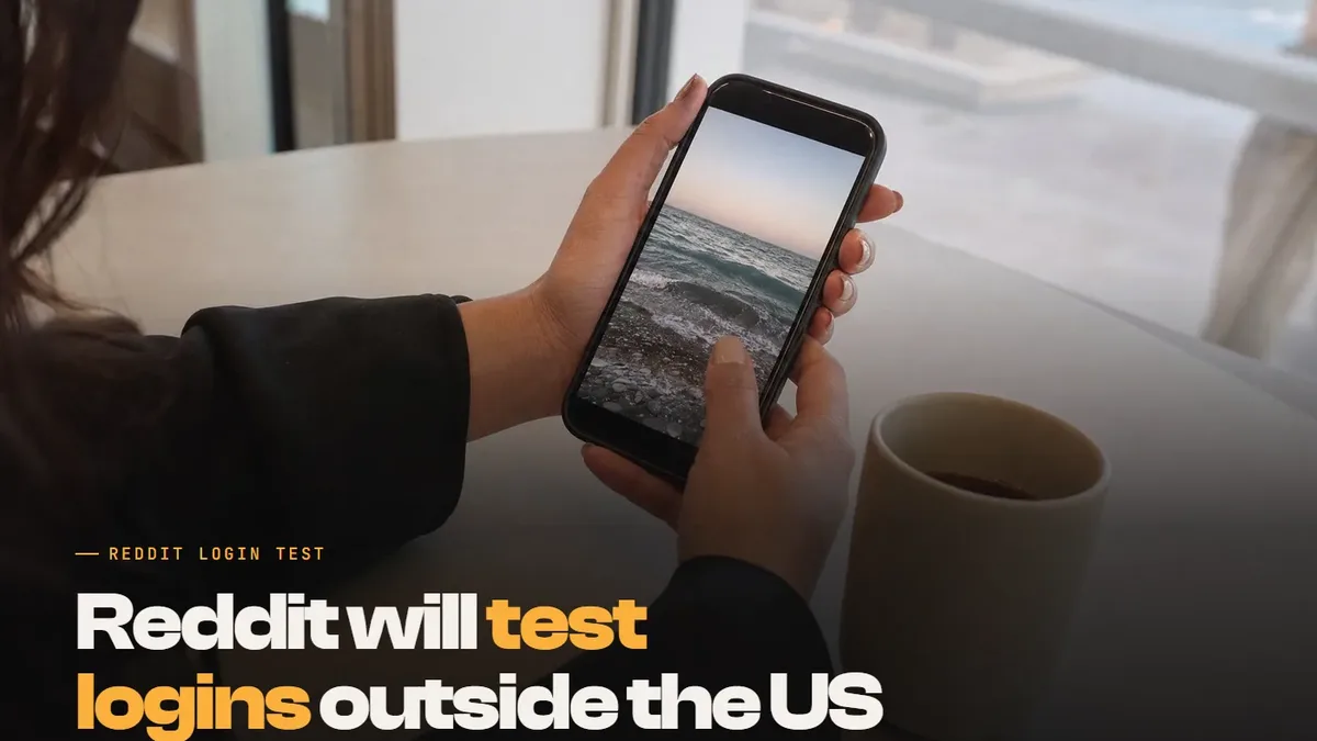 Hands holding a smartphone over a cafe table in Dubai, with the text: Reddit will test logins outside the US