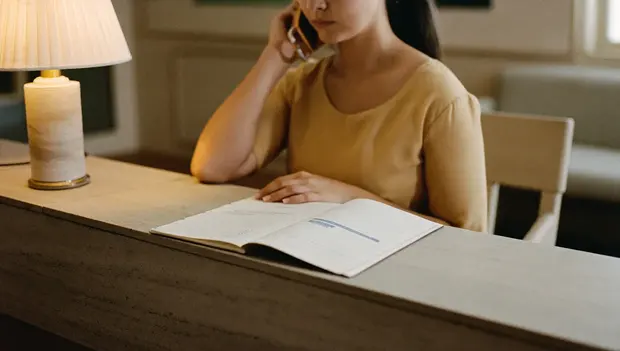 Clinic receptionist on a call with an appointment diary open
