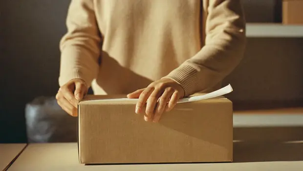 Packing a customer order at an e-commerce fulfilment bench