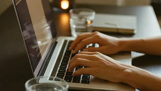Hands typing on a laptop while building a booking portal