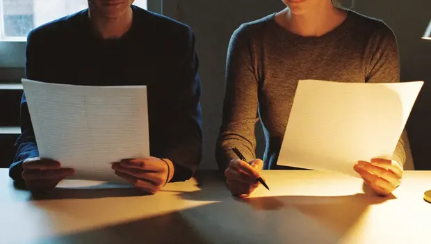 Two colleagues reviewing financial documents at a desk