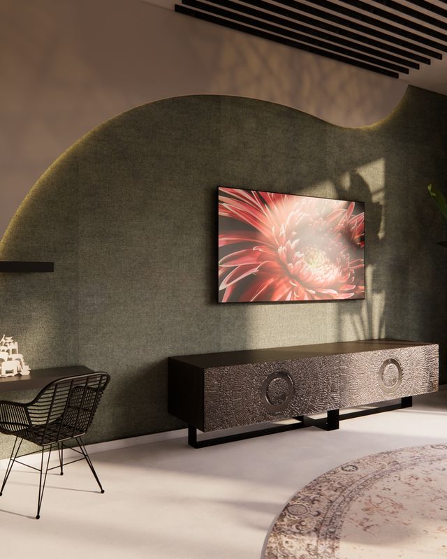 Detail van de TVhoek met groene accentwand, hangplanten, wandplanken en rustig maatwerk in de woonkamer.