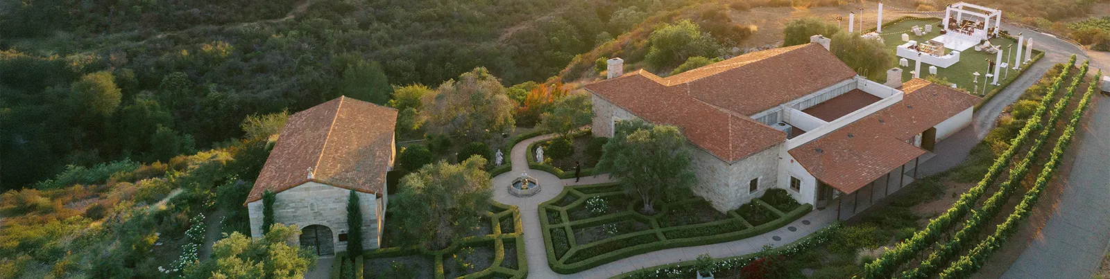 The wedding gardens at Cal-a-Vie — a stone fountain and French country building framed by lavender on the Provençal hillside, northern San Diego County