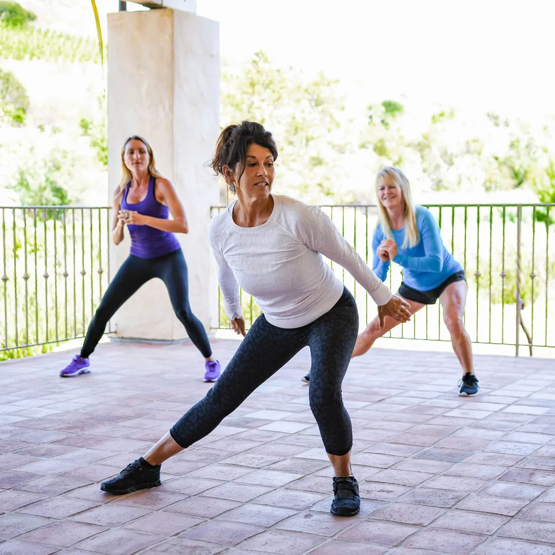 a group of women exercising on a patio