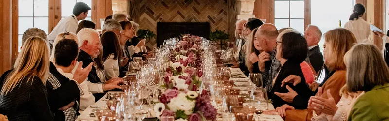 A group gathered around a flower-decked table at Cal-a-Vie, set for a celebration dinner