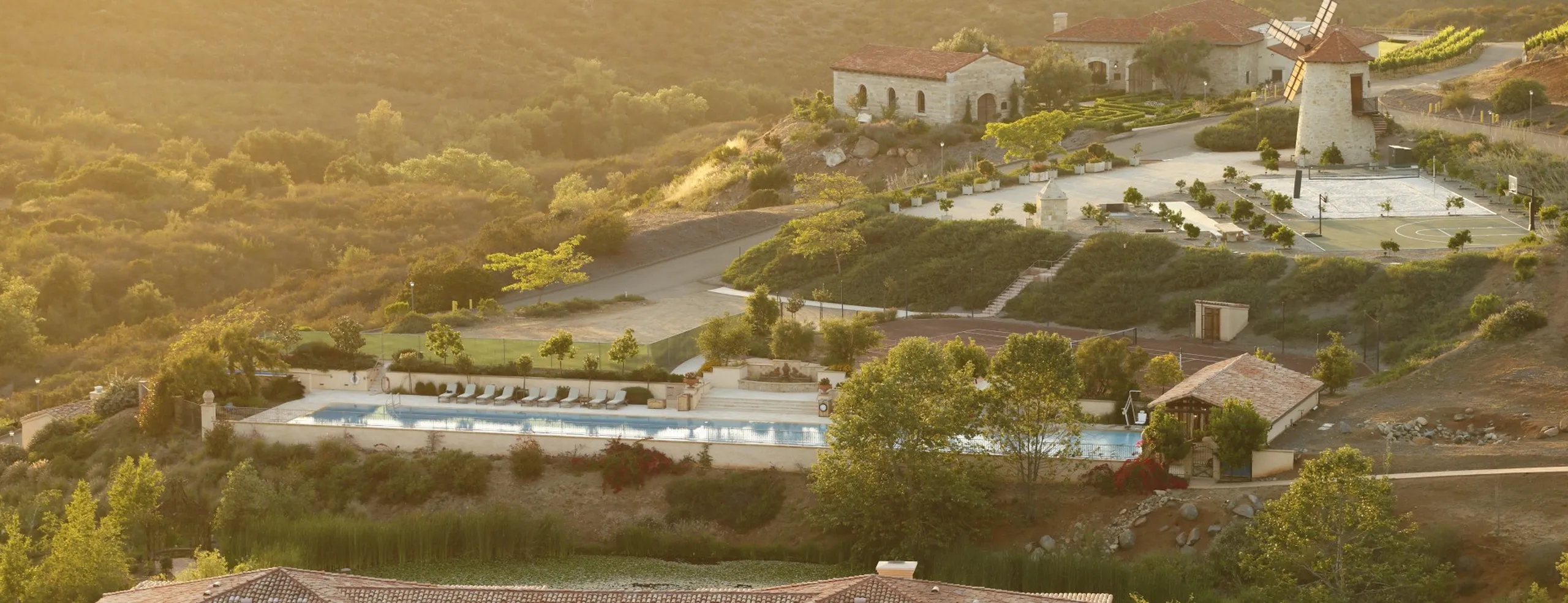 Aerial view of Cal-a-Vie at twilight — hillside villas, vine rows, and the estate grounds in golden evening light