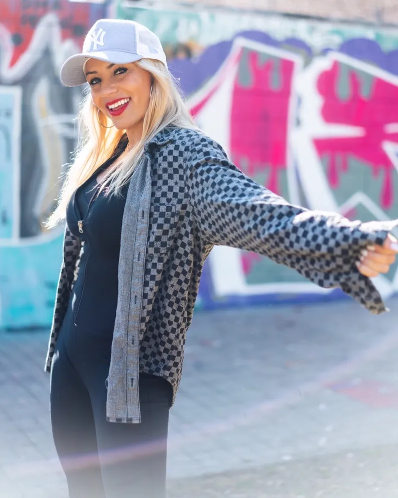 a woman wearing a hat and a grey jacket