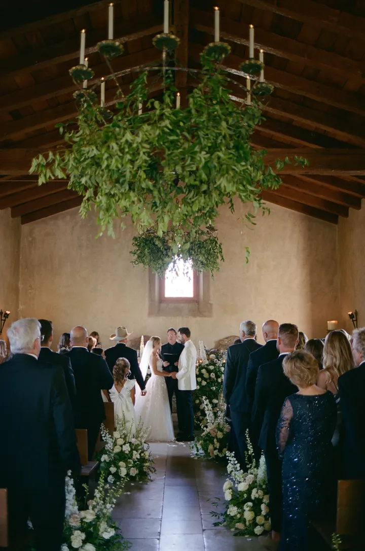 A wedding ceremony beneath hanging greenery in the 17th-century chapel at Cal-a-Vie Health Spa
