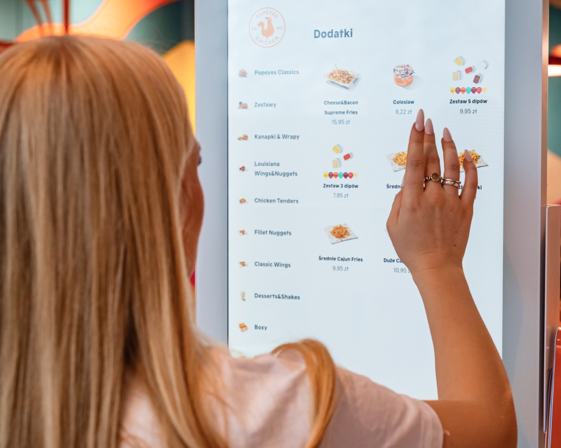 Guest browsing a kiosk menu on a large touch screen