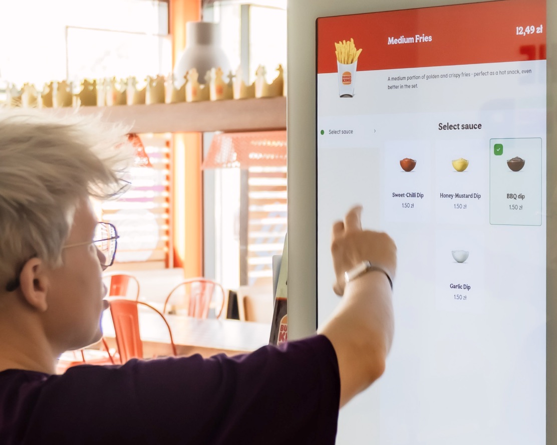 Guest choosing a sauce on a personalized kiosk menu