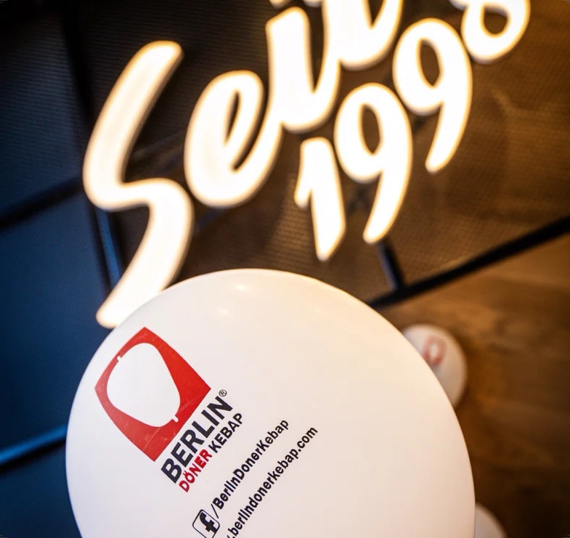 Berlin Döner Kebap balloon in front of the chain’s neon “Seit 1990” sign