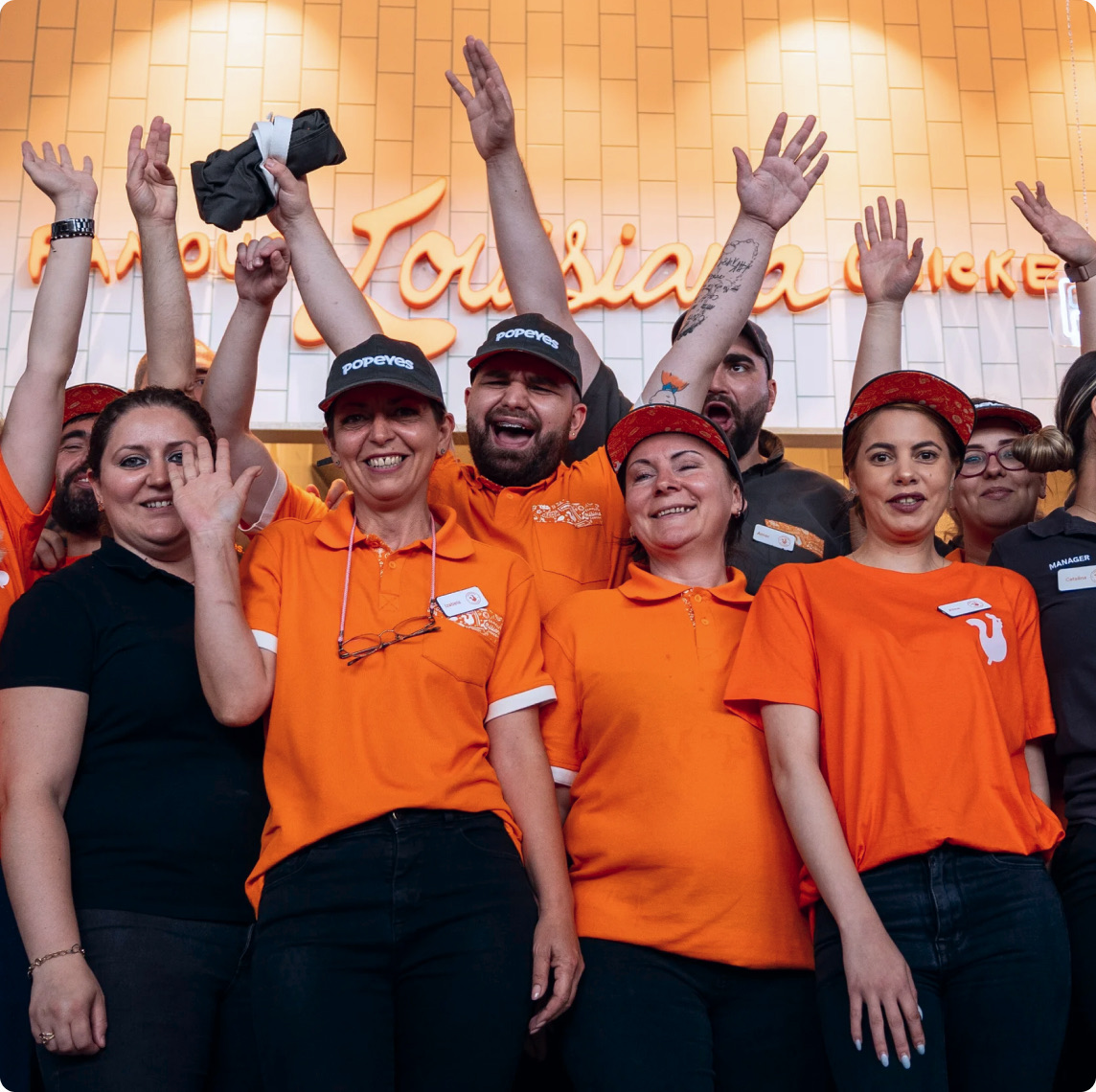 Cheering restaurant team in orange uniforms