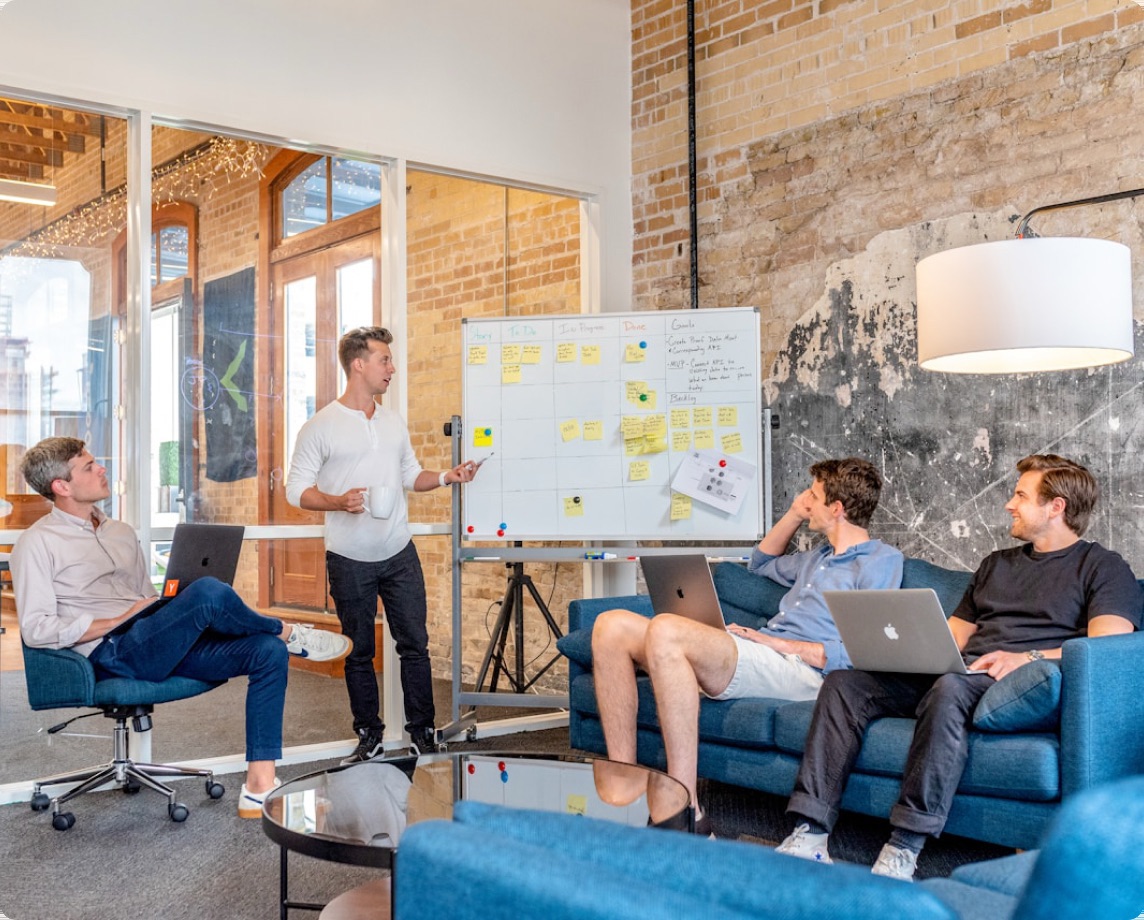 Team planning a rollout into new markets in front of a whiteboard