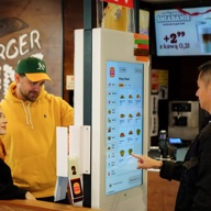 Guests ordering at a Burger King self-service kiosk