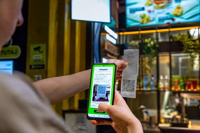 Guest scanning the Pasi Apka QR code from a receipt with a smartphone