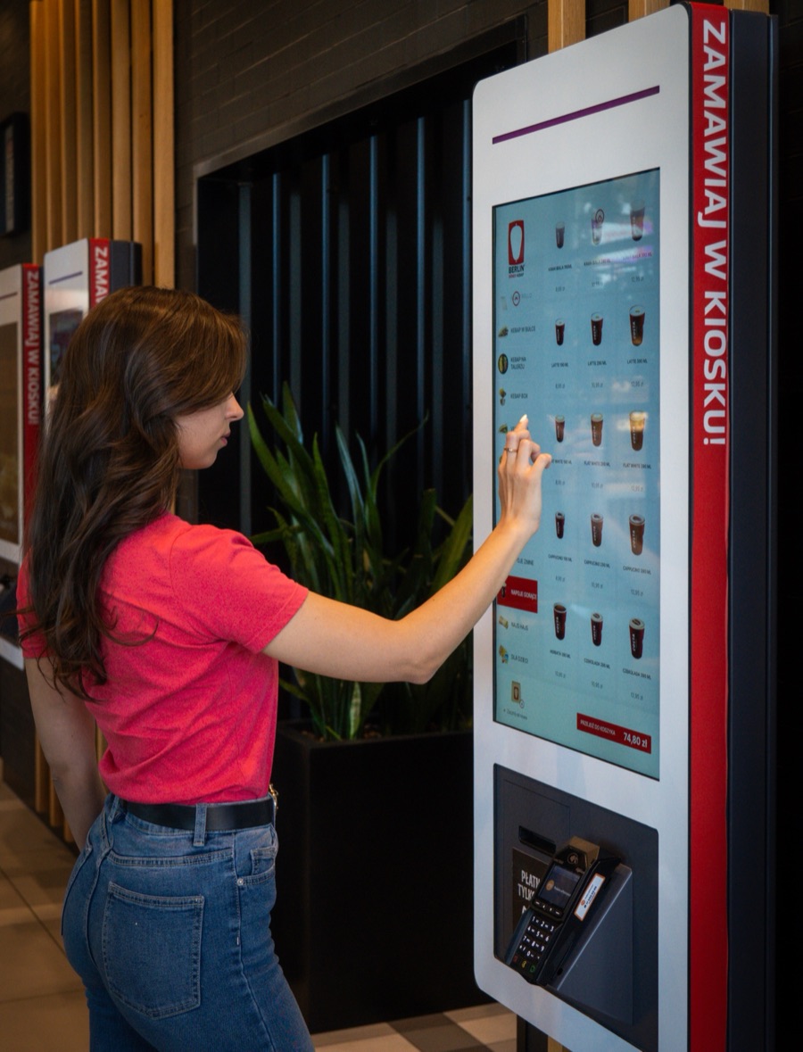 Guest ordering at a self-service kiosk in a quick-service restaurant