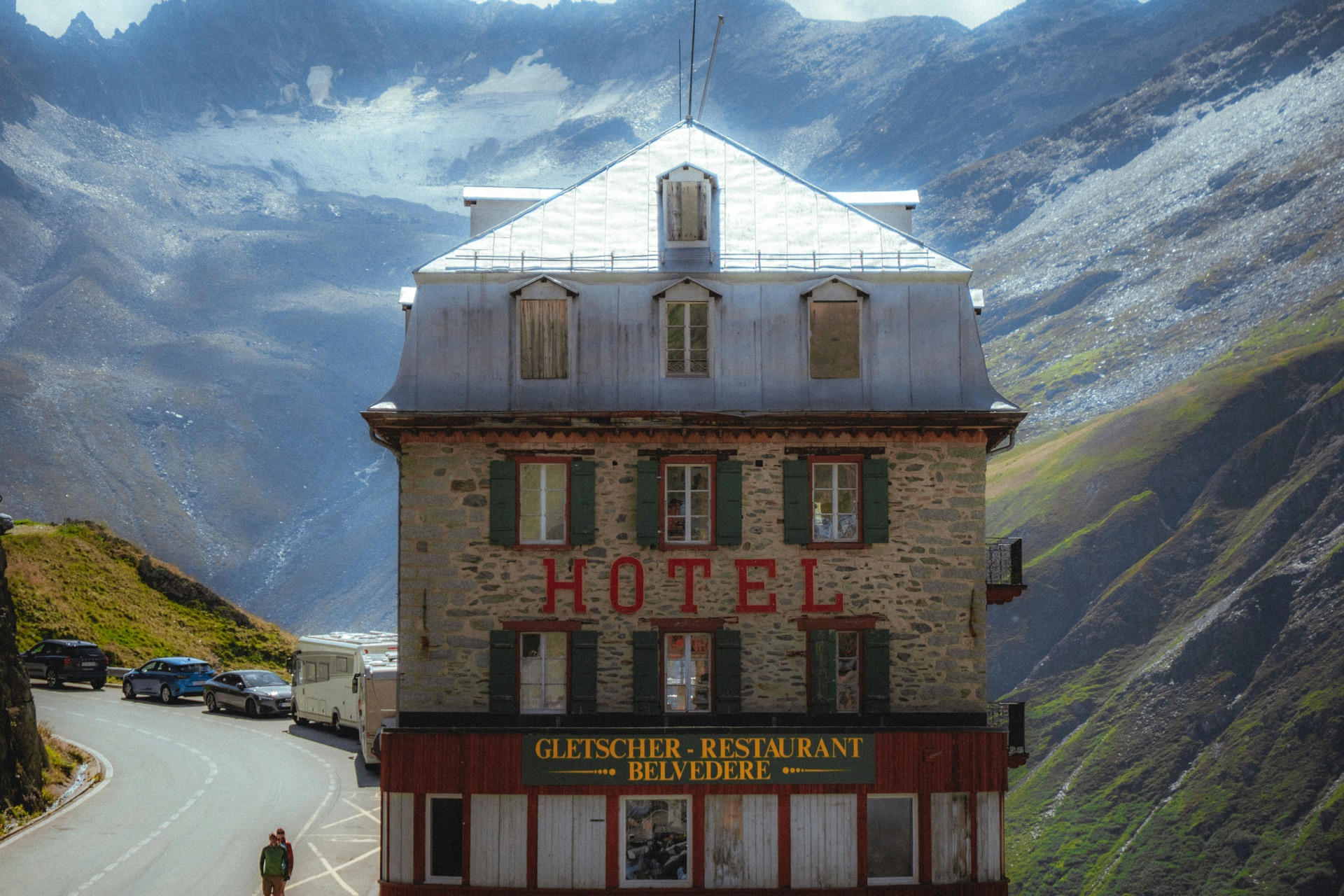 Ein historisches Berghotel mit Restaurant an einem Alpenpass unterhalb eines Gletschers.