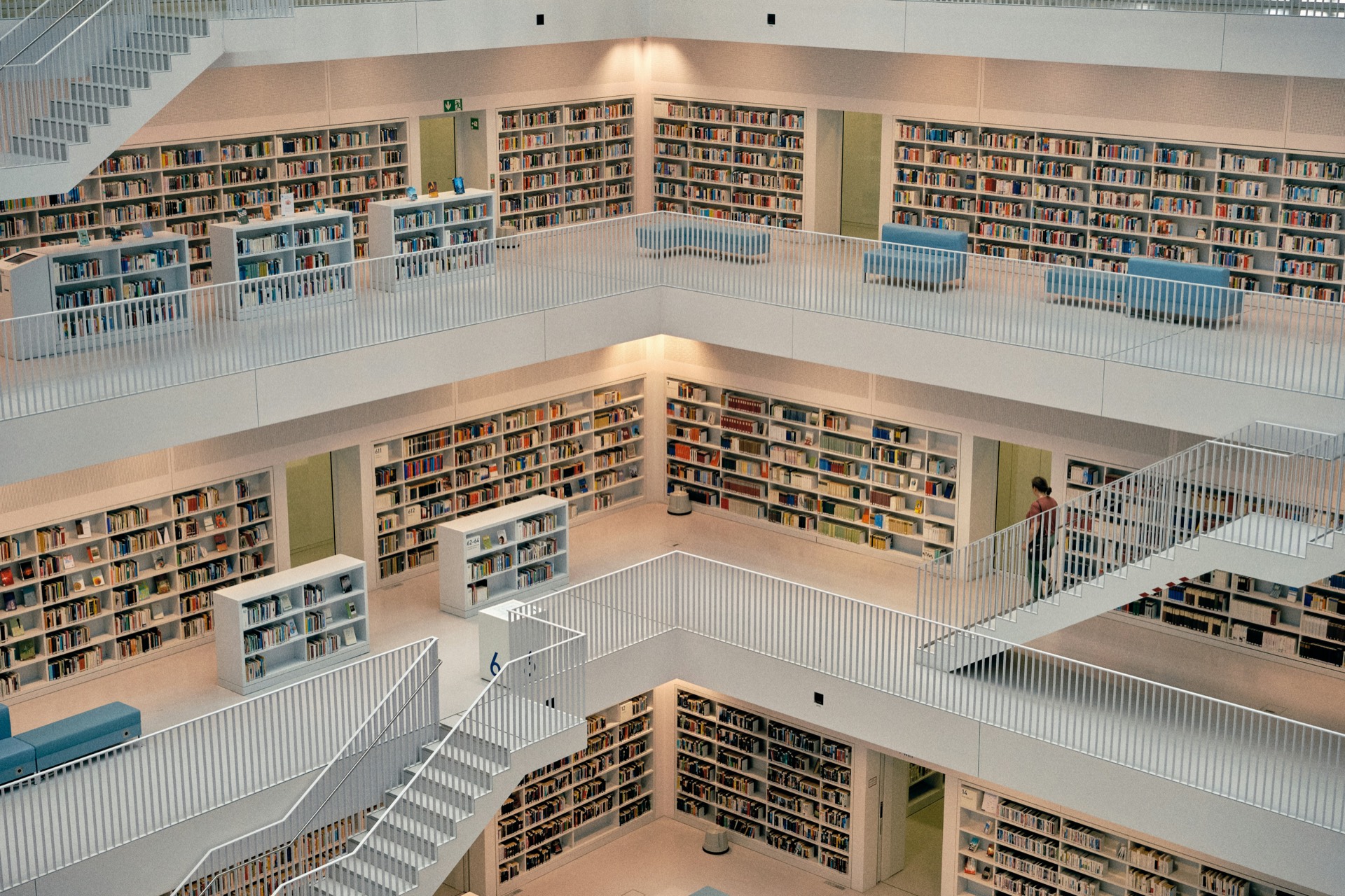 The multi-level interior of a modern public library filled with books.