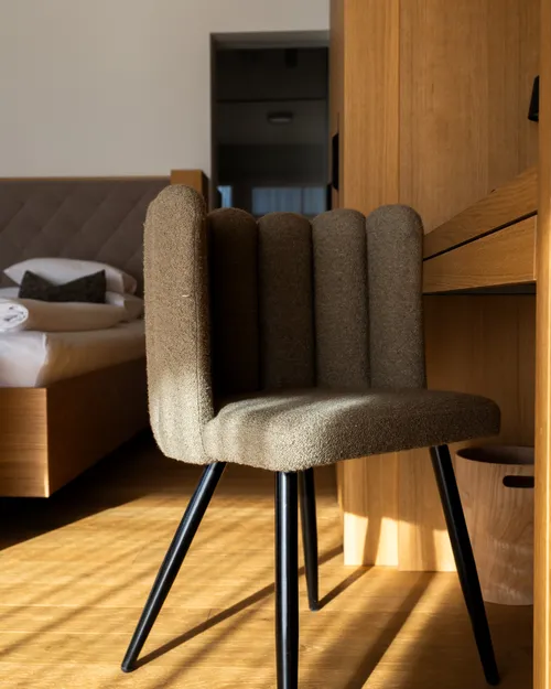 Gepolsterter Stuhl mit gerippter Rückenlehne im Hotelzimmer