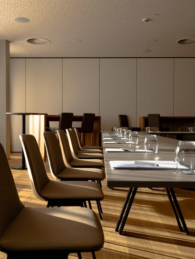Konferenzraum mit langem Tisch, Stühlen und Wassergläsern für ein Meeting