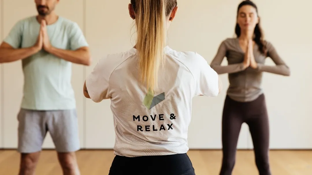 Yogakurs mit Trainerin und zwei Teilnehmern in Betsposition