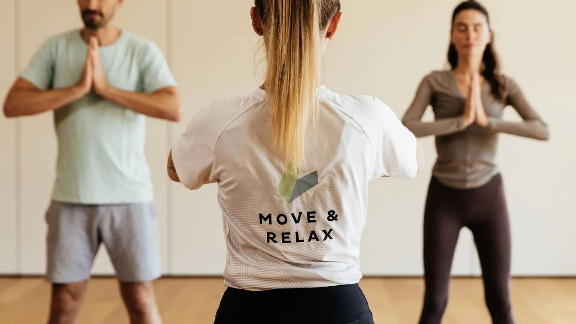 Yogakurs mit Trainerin und zwei Teilnehmern in Betsposition