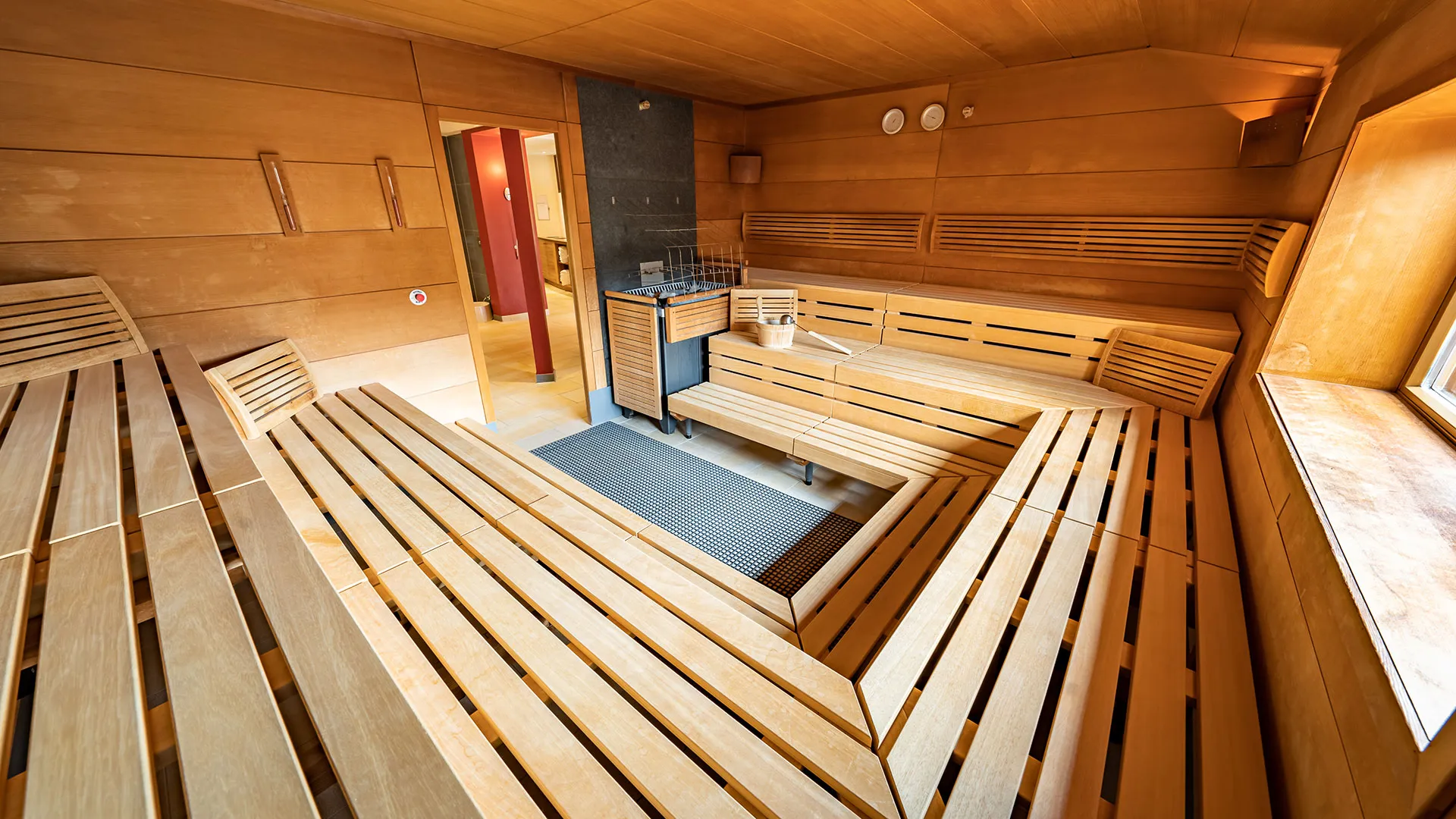 Holzverkleidete Sauna mit Sitzbänken und Saunaofen